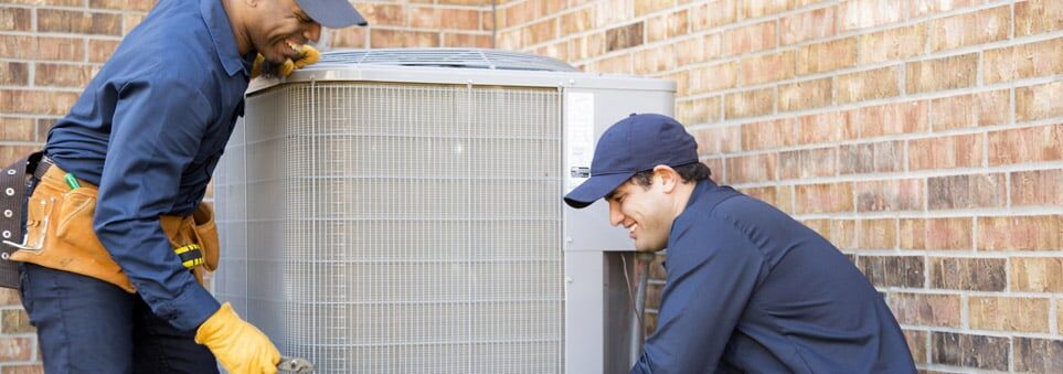 HVAC technicians installing a new furnace unit