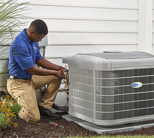 Air conditioning technician repairing an outdoor AC unit