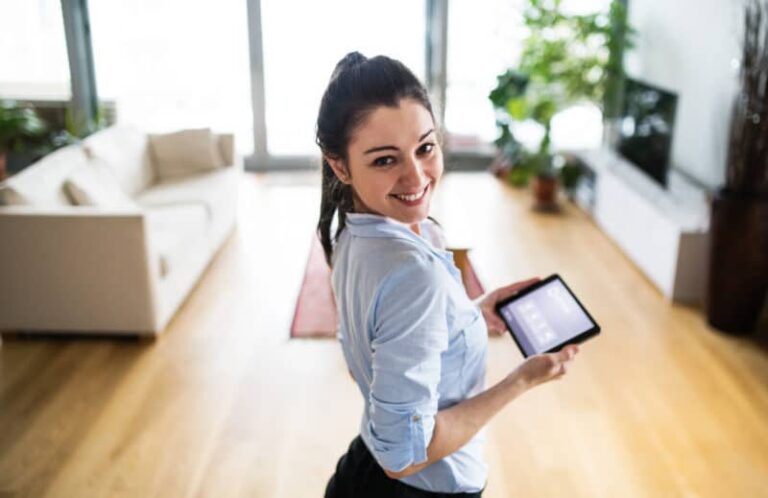 TECH woman controlling smart thermostat iStock  e