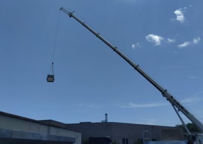 Air Specialty team using equipment to lift a commercial HVAC unit